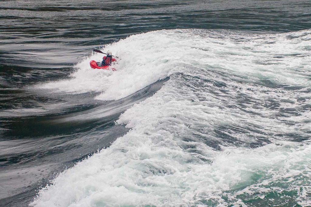 kayaker in all red plays in the whitewater of Skookumchuck Narrows